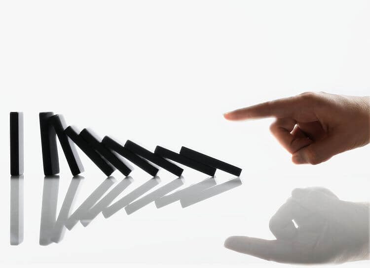 Businessman Touching Domino Pieces Arranged in a Line